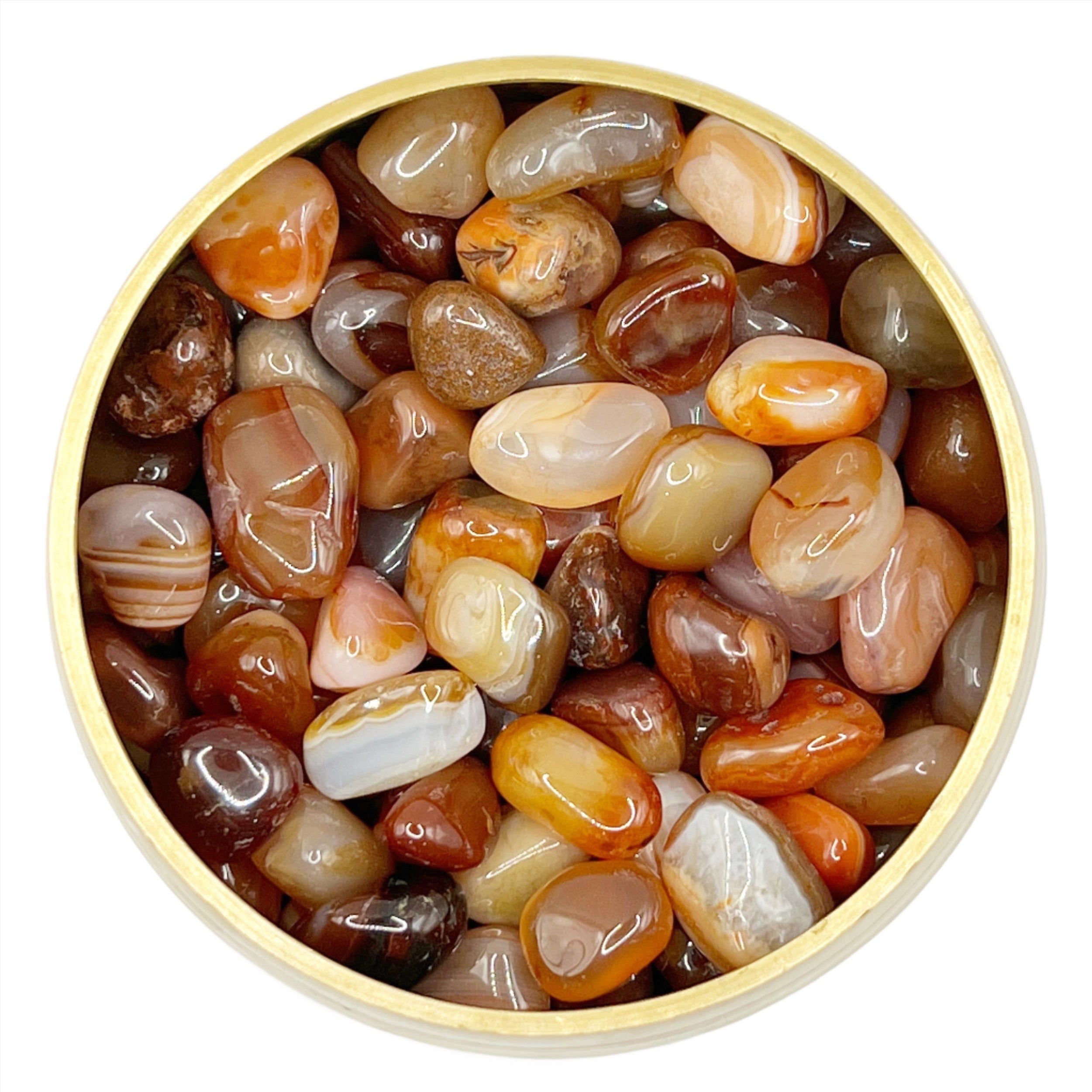 Carnelian tumbled stones in a circular dish, showcasing orange and red hues for motivation and vitality benefits.