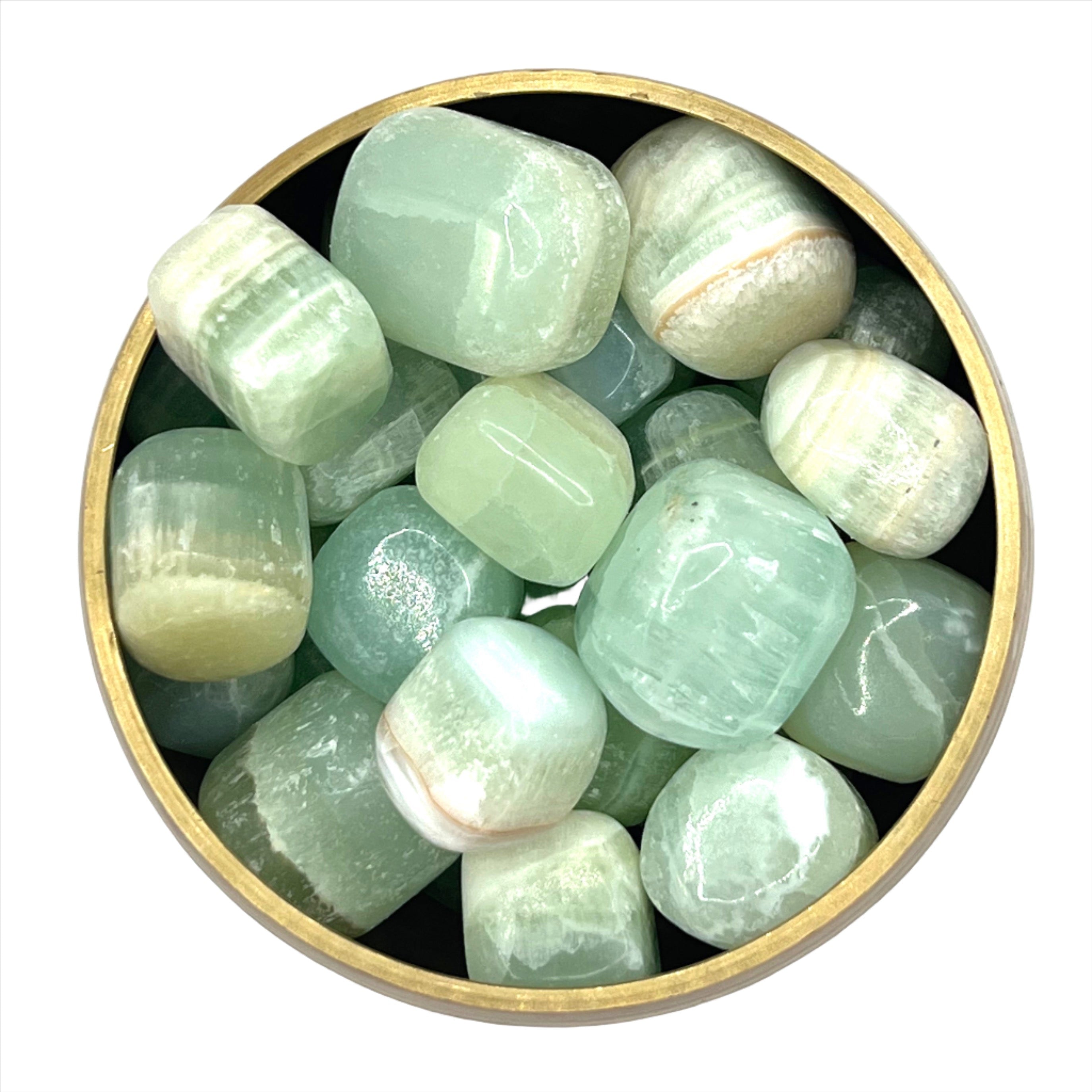 Tumbled green calcite stones in a brass bowl for mental balance and emotional healing.