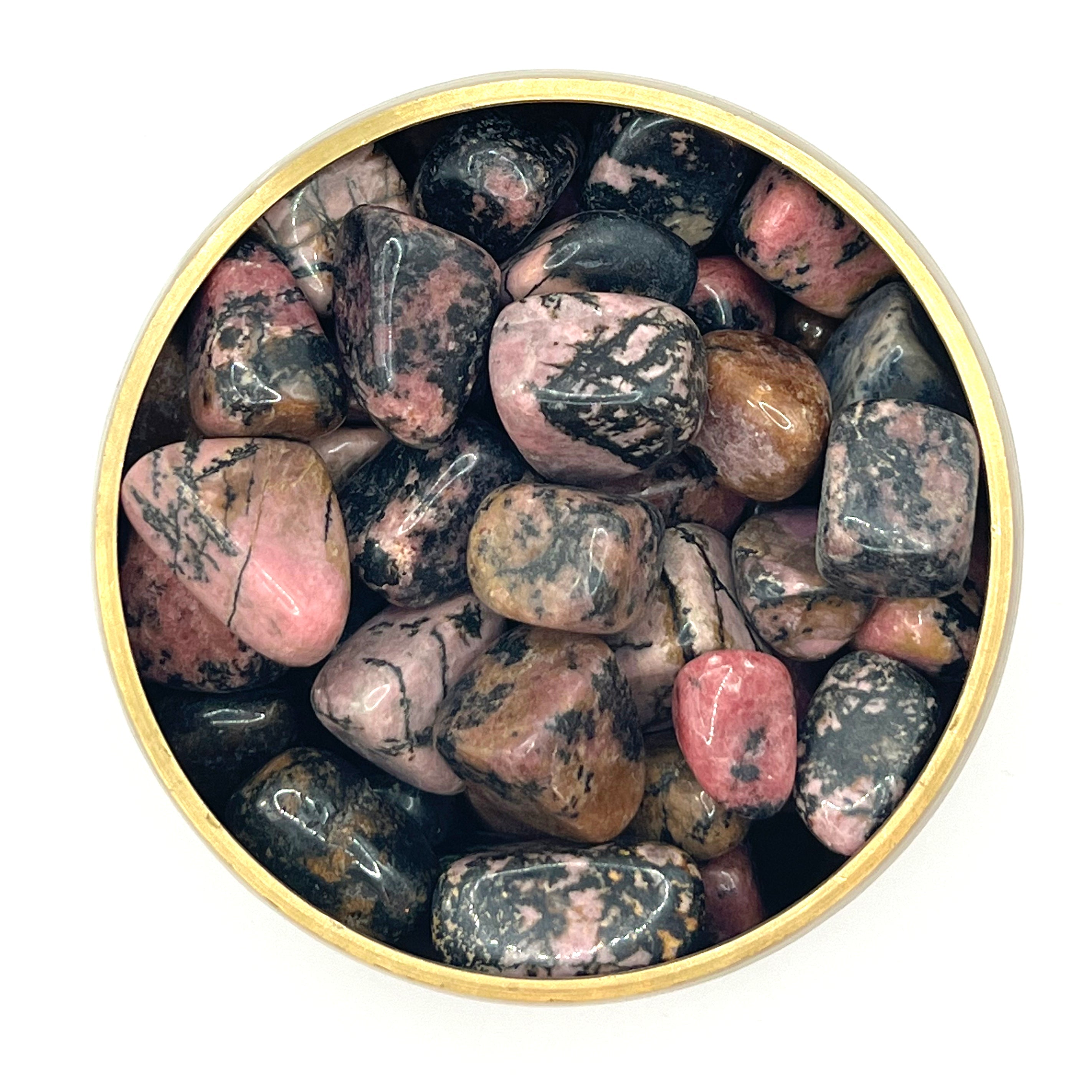 Assorted Rhodonite tumbled stones in a circular dish, showcasing vibrant pink and black patterns for healing and meditation.