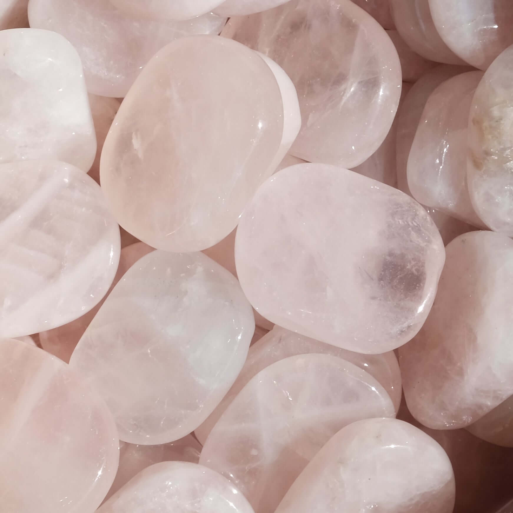 Rose Quartz Tumbled Flat Stones for self love and healing, enhancing confidence and heart health, against a soft background.